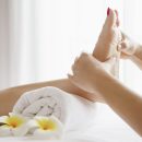 Woman receiving foot massage service from masseuse close up at hand and foot - relax in foot massage therapy service concept